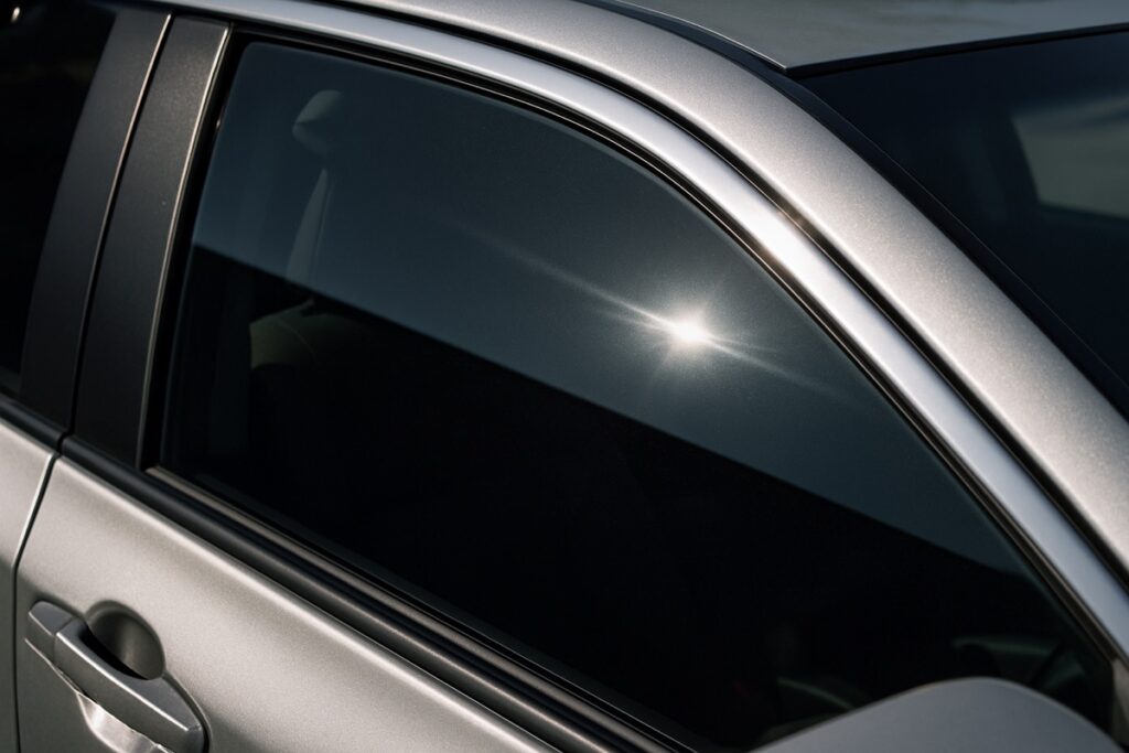 Close-up of a car side window with dark ceramic tint film